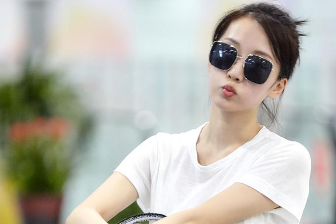 李念白衣飘飘搭配丸子头现身机场尽显率性style