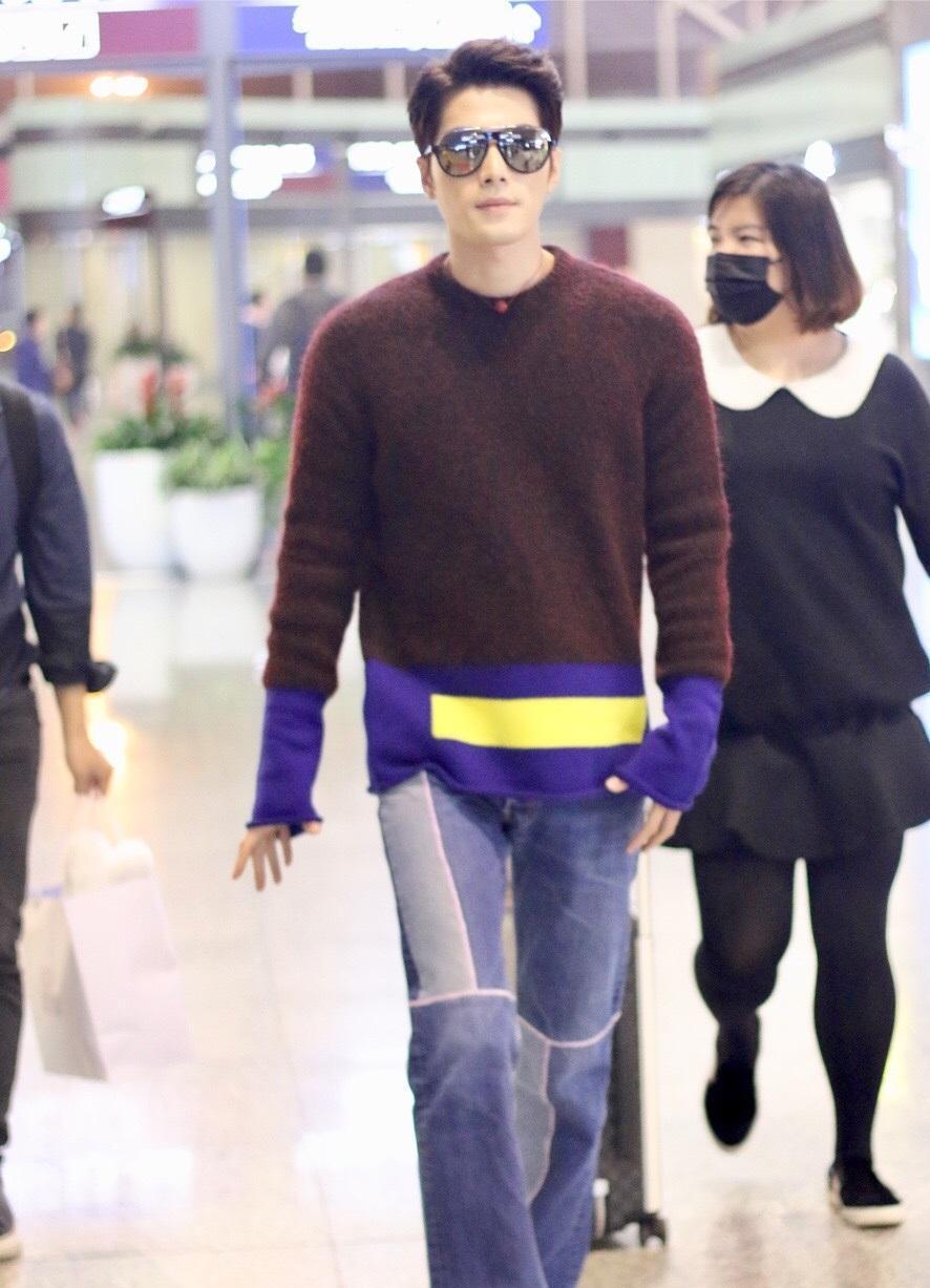 陈学冬现身机场全身拼接造型温暖时尚, 脖间红色转运珠抢眼