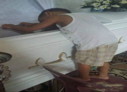 男孩幼小的心灵接受不了母亲离世的现实,在母亲的葬礼上,他久久的趴在