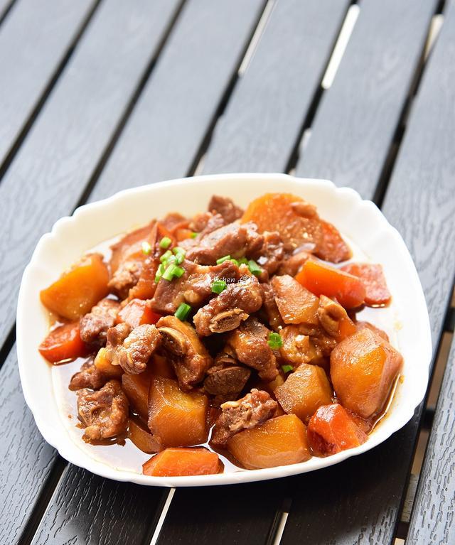 4 土豆和胡萝卜削皮切块,把腌制好的排骨,土豆块和胡萝卜块一起放进