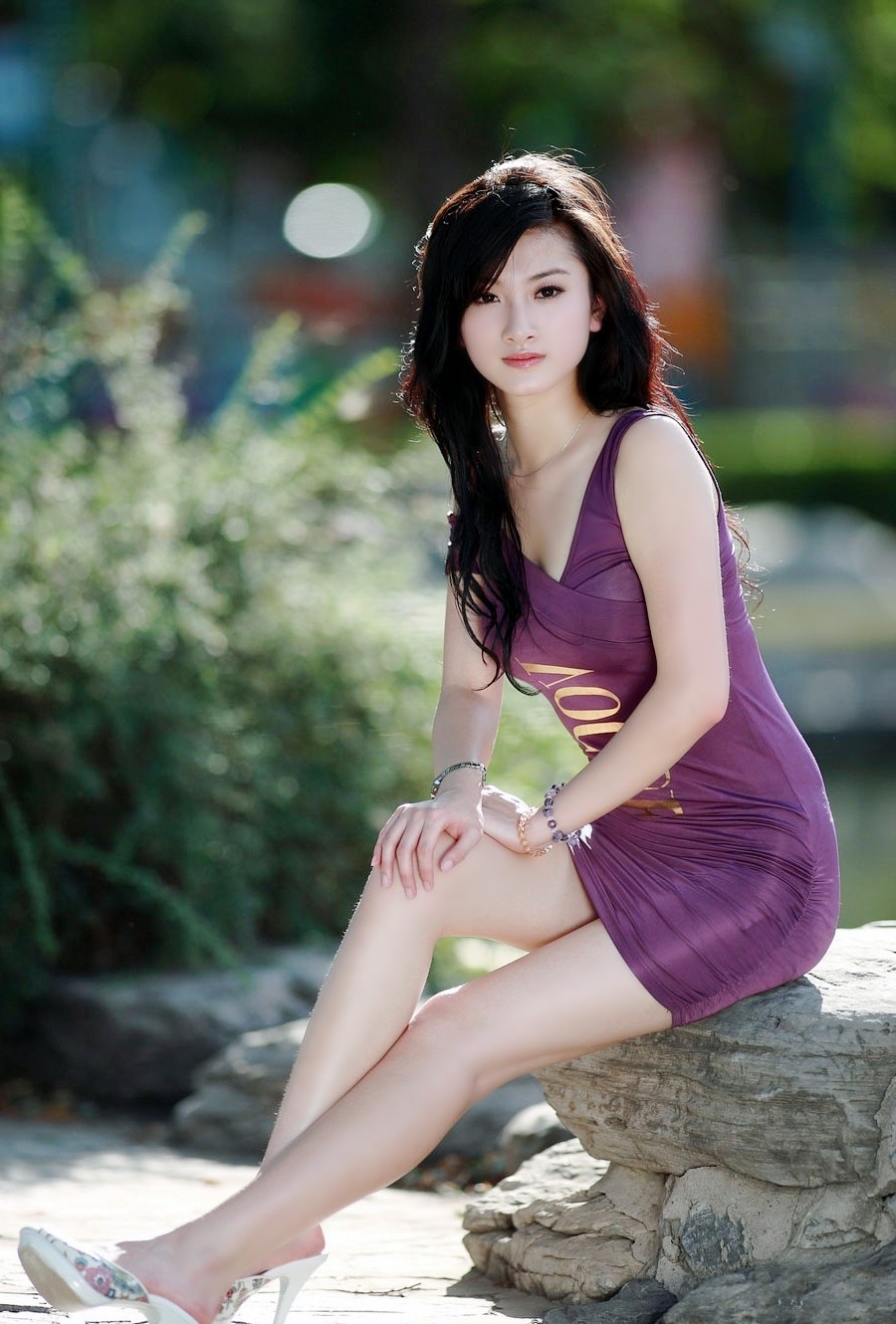 透过公园的阳光下一个青春美丽白皙女子