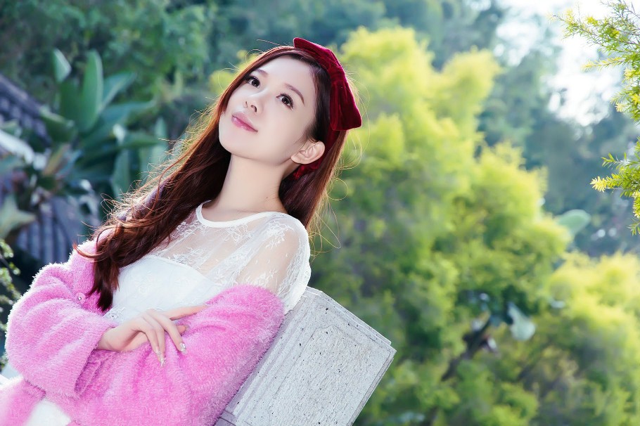 一个在户外美景下的艳丽红衣美女