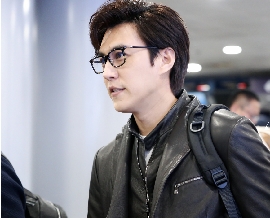 靳东戴着黑框眼镜身穿黑色皮夹克搭配深蓝色休闲现身机场帅气十足