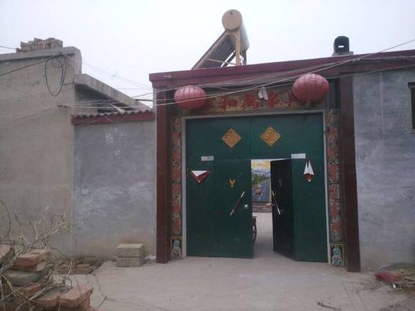 在农村有些住宅的大门上吊挂着一面镜子