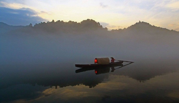 晨雾朦胧泛小舟江中一网滤千愁