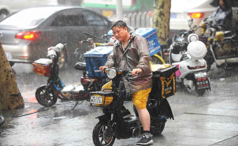 暴雨袭江城外卖小哥雨中疾驰送餐忙