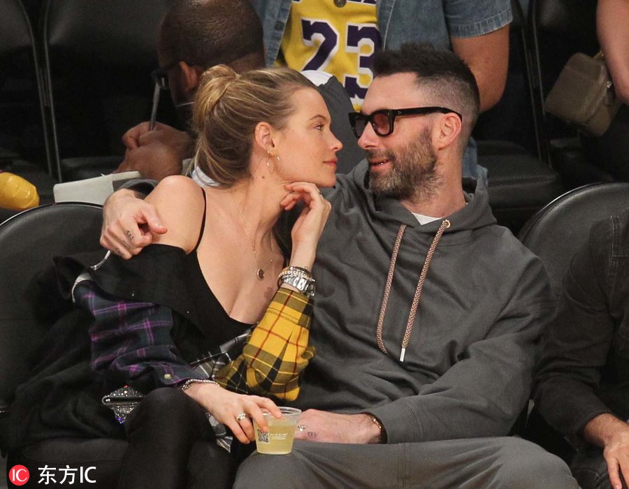 场边歌手亚当-莱文携超模妻子普林斯露观战.(图片署名: 东方ic)