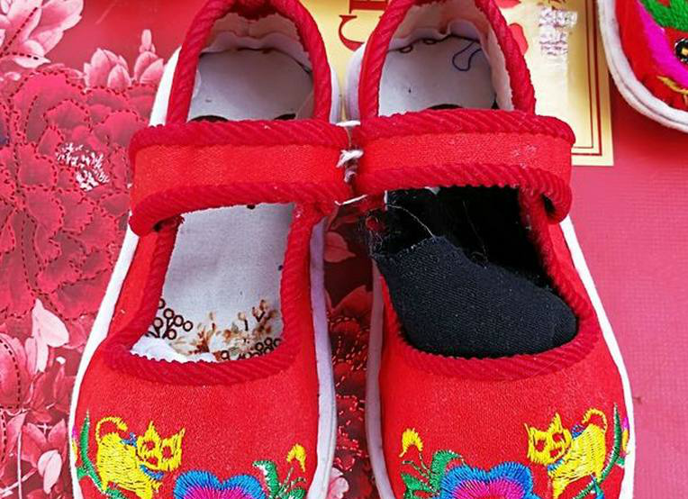 青岛武家庄大集上拍摄的虎头鞋,缝制这鞋的竟然是一位78岁的老人.