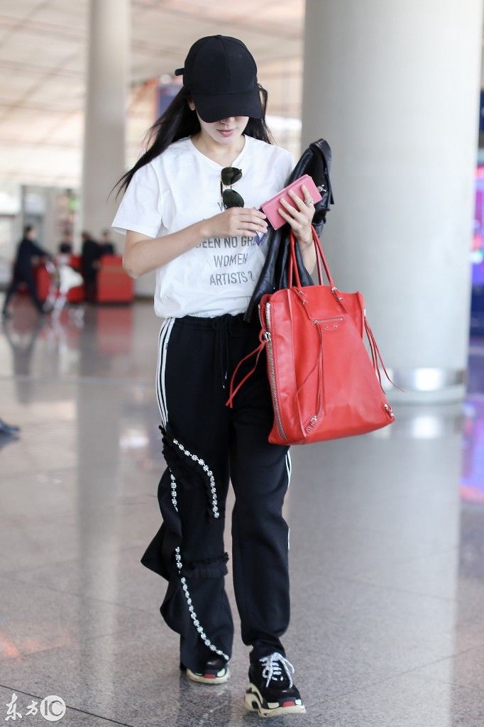 娄艺潇穿白色字母t恤搭配黑色运动裤现身机场,捂嘴偷笑好可爱!