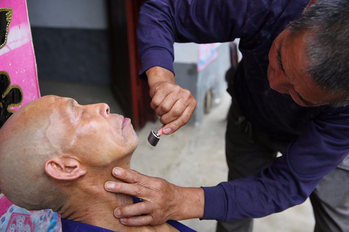 大山里的留守老人互助剃光头 5分钟刮光一个头