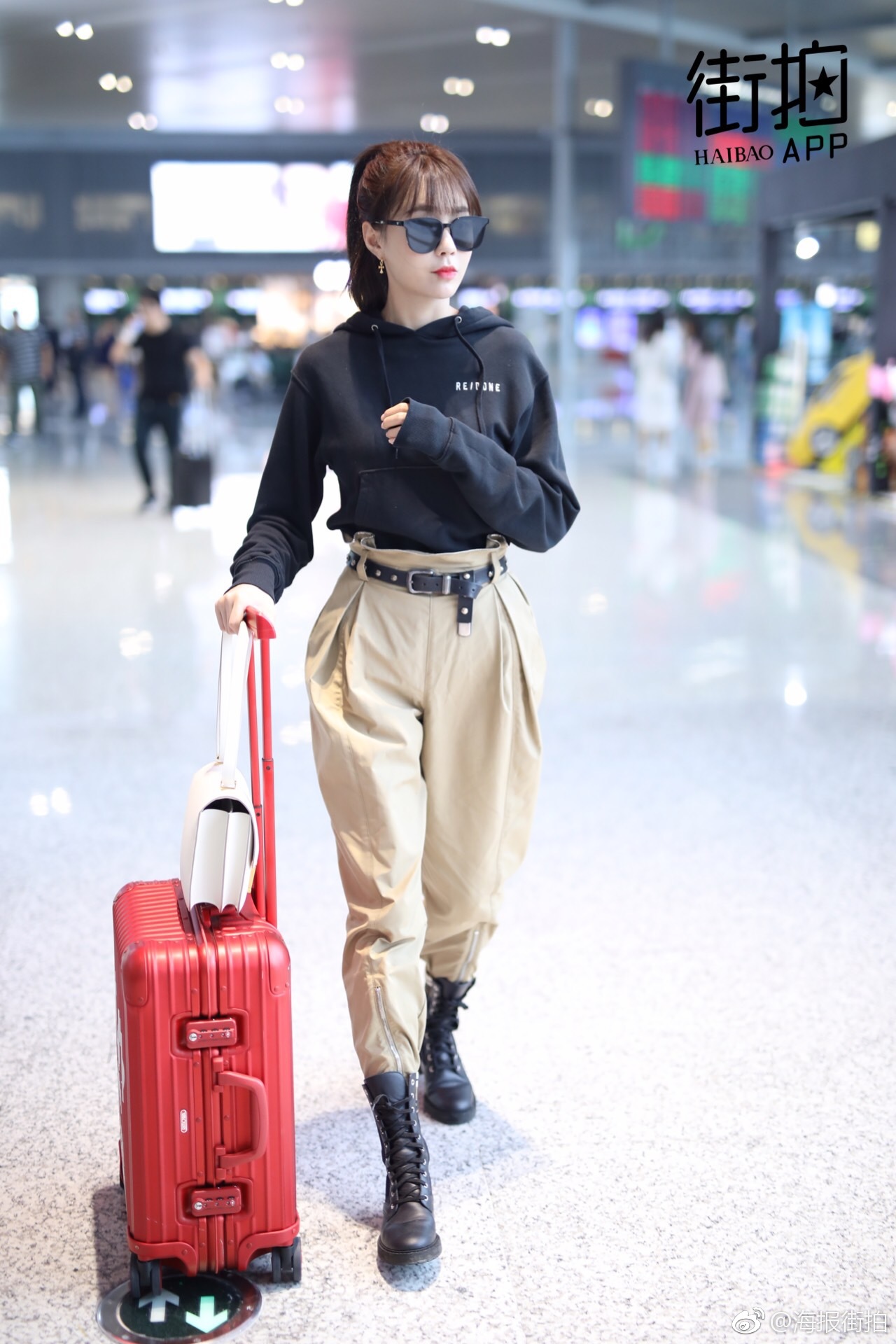 机场照,黑色帽衫搭配卡其色休闲裤和短靴,高腰的穿法帅气有型