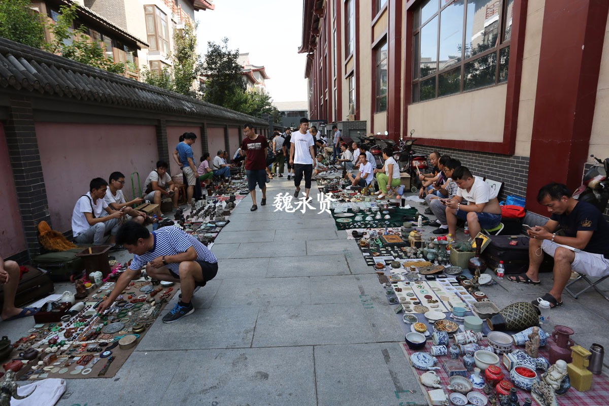 7月21日,周六,西安大唐不夜城,楼与楼之间的空地上摆满了卖古玩的地摊