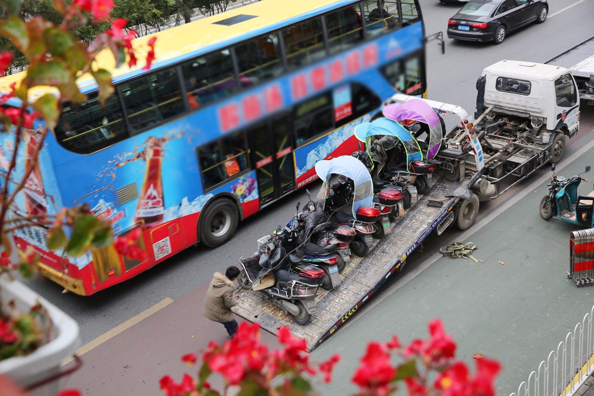 交警设点查违法电动车上路行驶,没有牌照的电动自行车被扣后被拖车拖