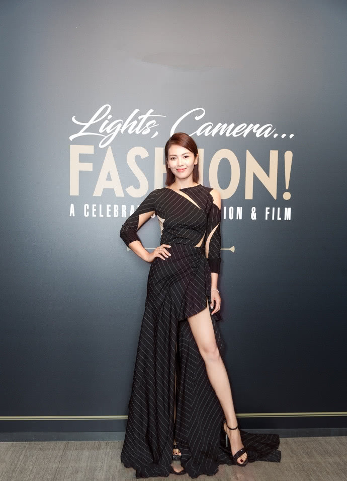 上图中刘涛身穿一袭黑色条纹开叉长裙,束腰露腿的设计完美的勾勒出她