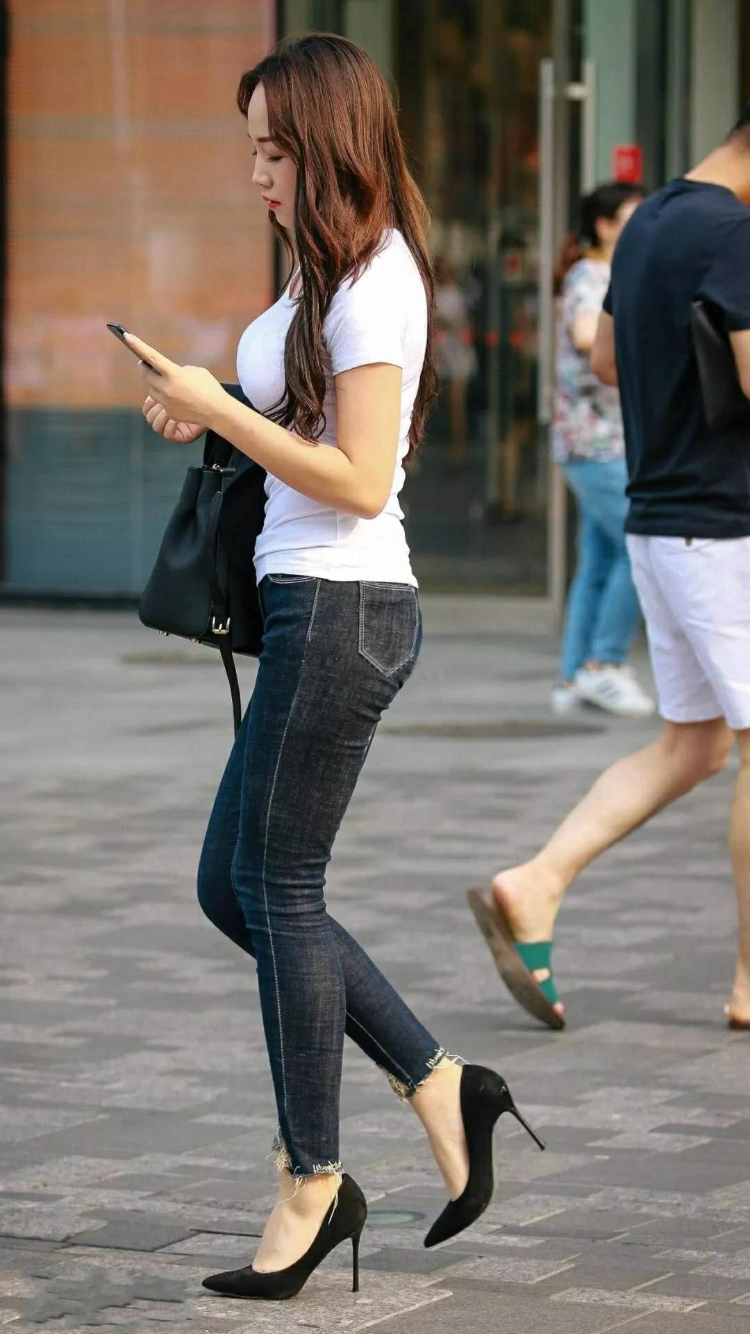 街拍俏皮小姐姐小白t搭配牛仔裤高挑身材风韵十足