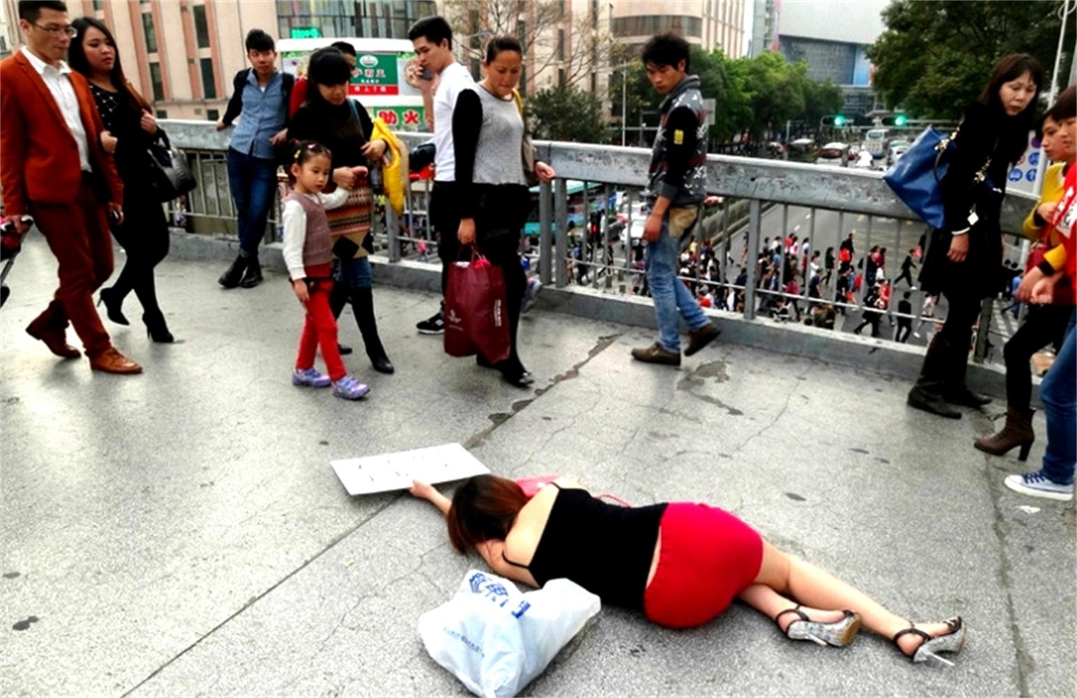 女子"晕倒"在大街上, 看到她手中牌子, 没有人敢扶她!
