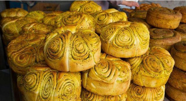 在普通发面里卷进菜油,抹上红曲,姜黄,香豆粉等民间食用色素,再层层叠