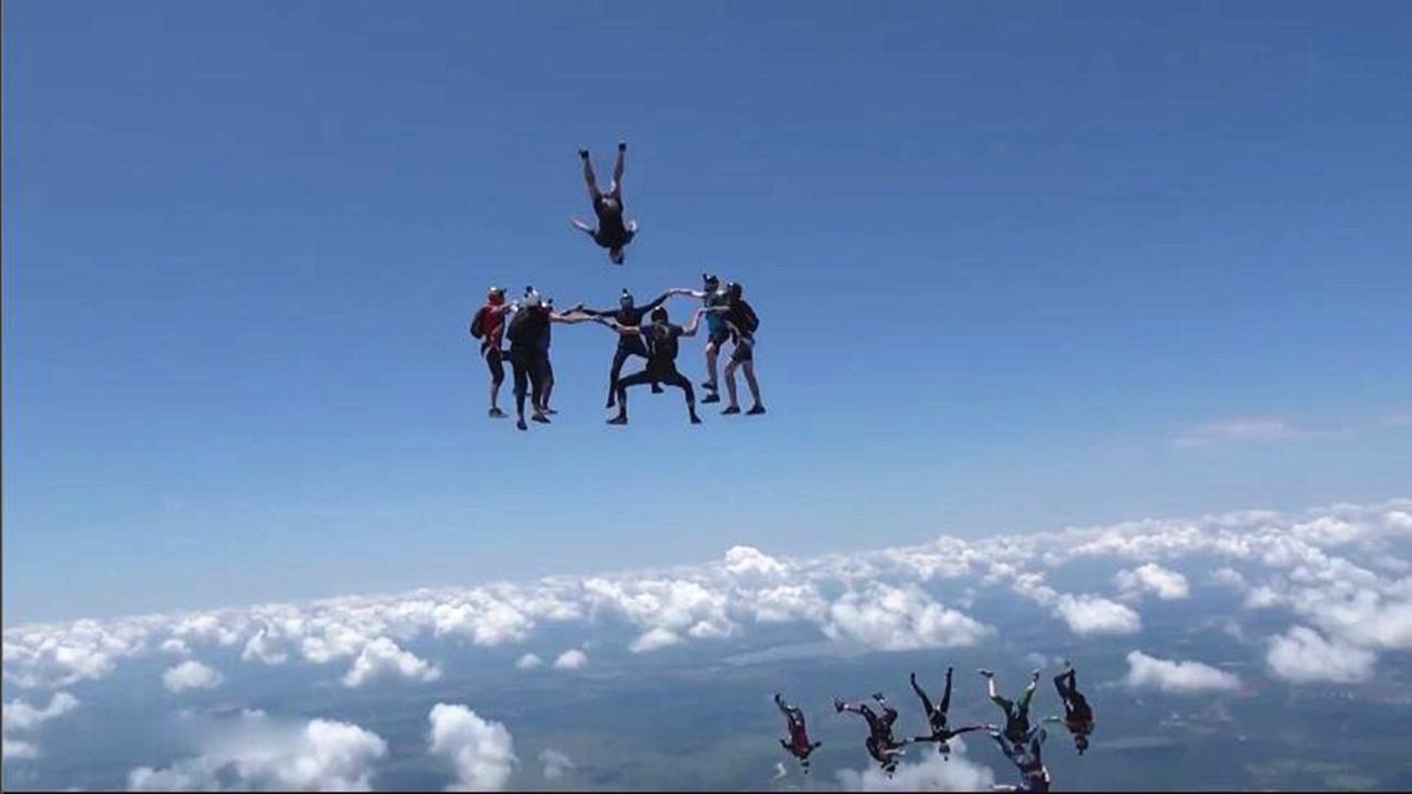 惊险花式跳伞多名跳伞队员空中牵手组圈等一人跃入