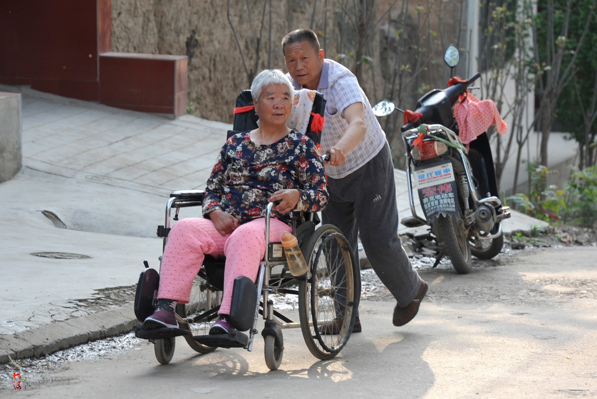 6旬大爷推半身不遂妻子马路边看车:让她高兴一天是一天