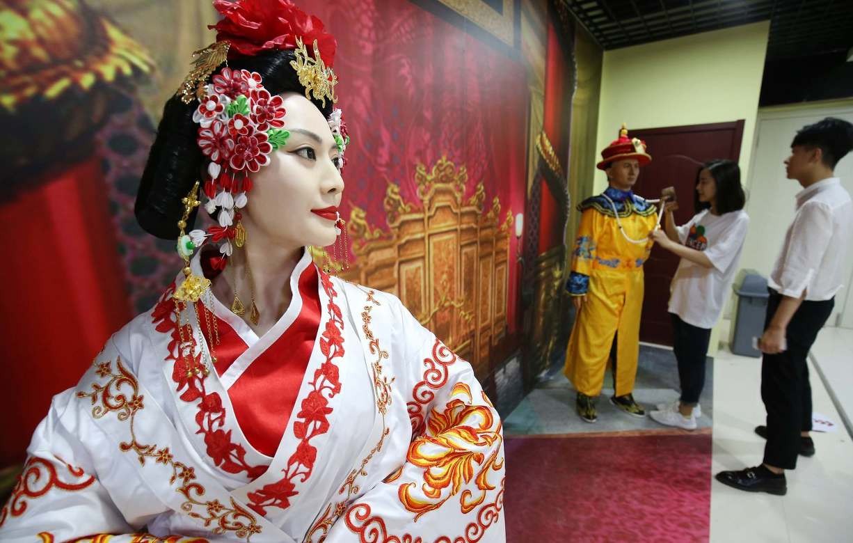 商场为吸引顾客目光举办蜡像展 一名蜡像保安执勤躺椅上睡着了