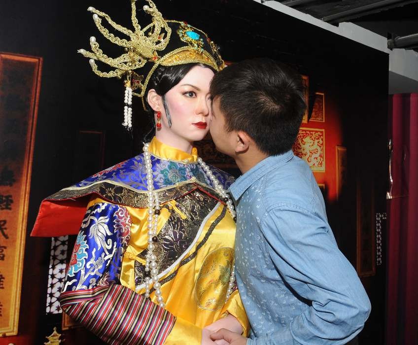 商场为吸引顾客目光举办蜡像展 一名蜡像保安执勤躺椅上睡着了