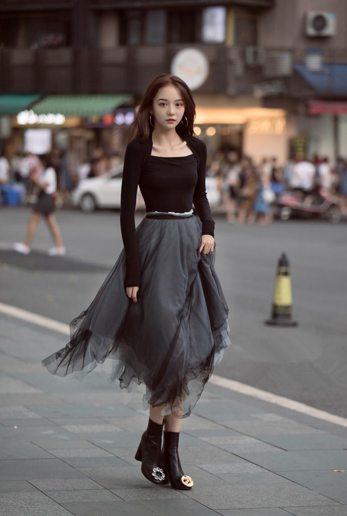 路人街拍:穿一袭黑色纱裙的小姐姐,透明的裙摆映出美丽的小腿
