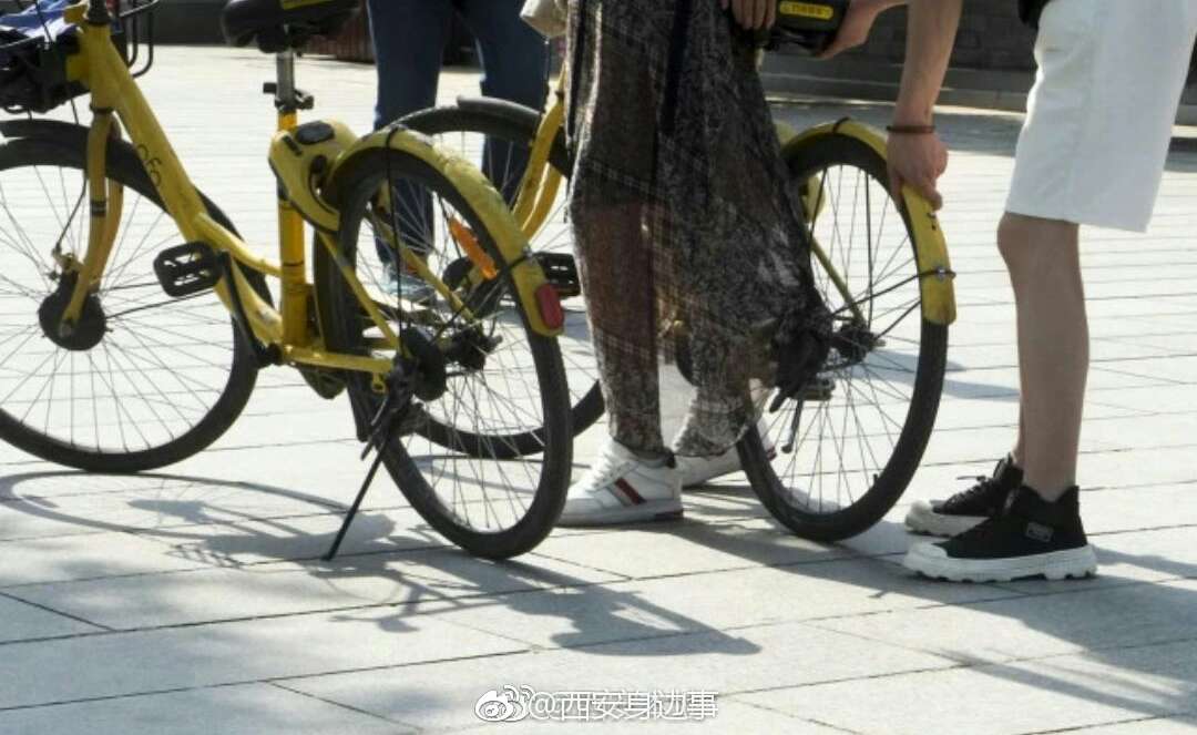 西安一女孩穿长裙骑单车 裙摆被卷进车轮