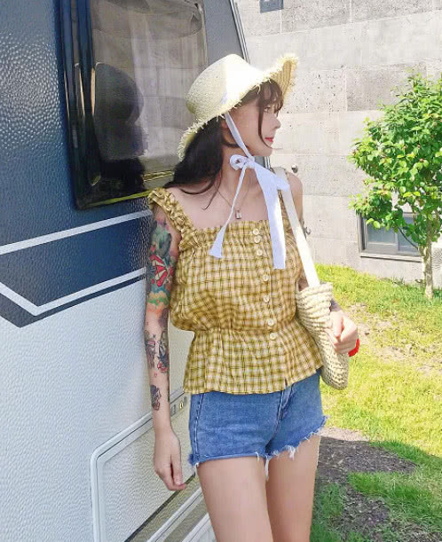 韩安冉穿着一件黄色方格吊带衫搭上一条蓝色超短牛仔裤,看起来就很有