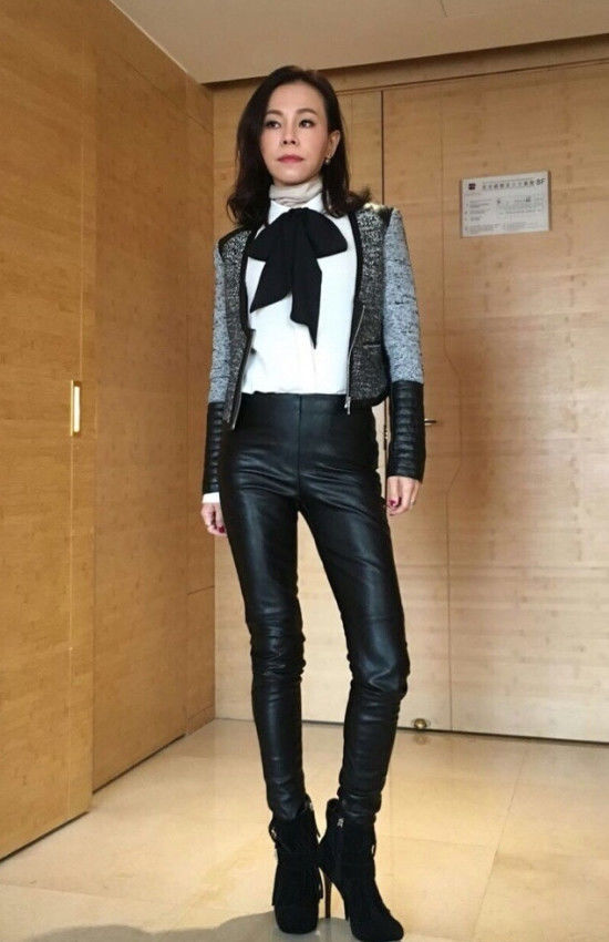 彭佳慧一件白色衬衣搭配一条黑色皮裤,脚踩黑色高跟鞋,真是性感迷人又