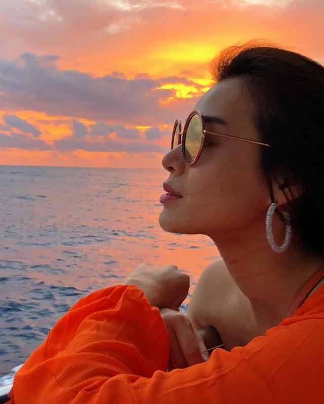 胡杏儿穿着露肩装,戴着墨镜,享受夕阳下海边的美景,景美人更美!