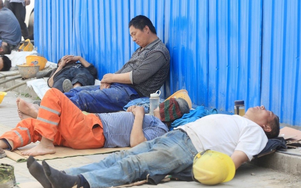 河南省郑州市郑东新区,民工们席地而睡,枕着石头台阶头,把人行横道