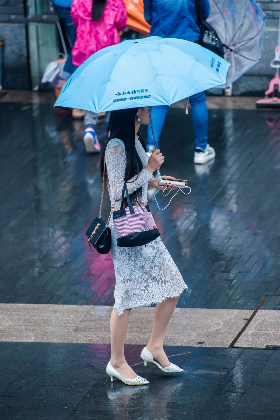 街拍雨中撐傘的肉絲白高美女蕾絲長裙盡顯江南女子柔美