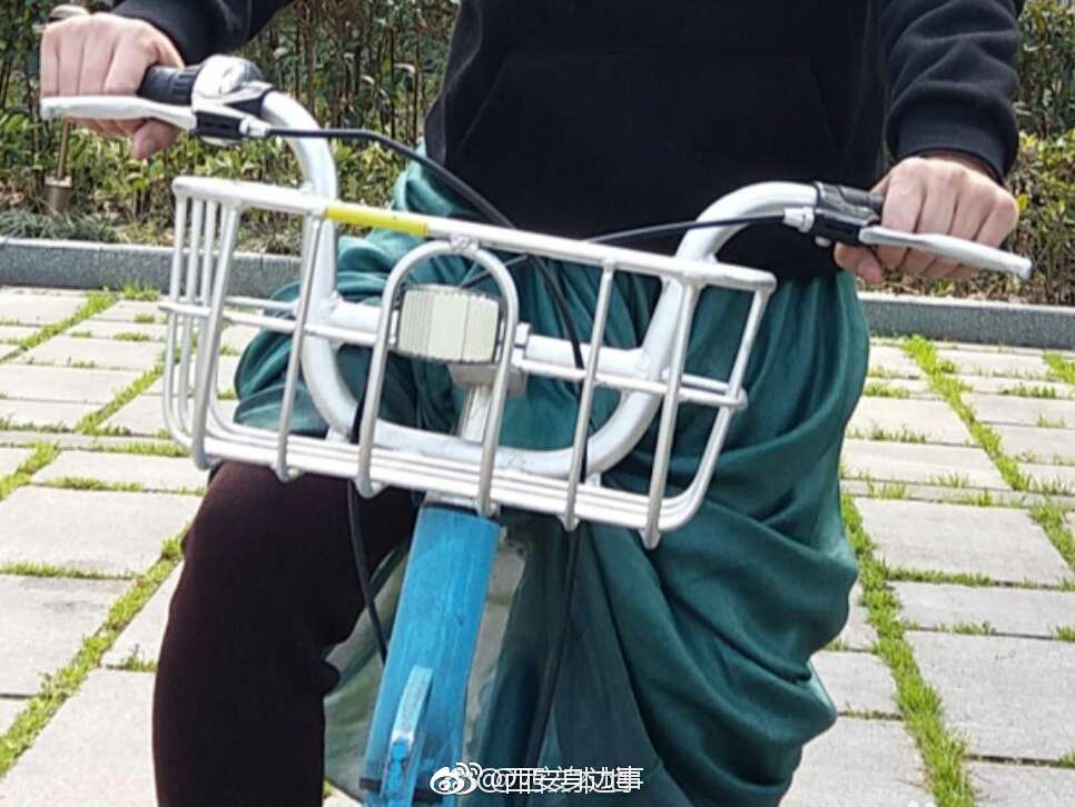 西安一女孩穿长裙骑单车 裙摆被卷进车轮