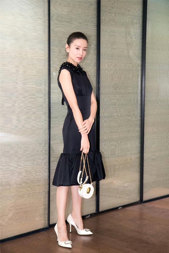 董洁脚上白色的高跟鞋链条包包的搭配给人一种很时尚的感觉