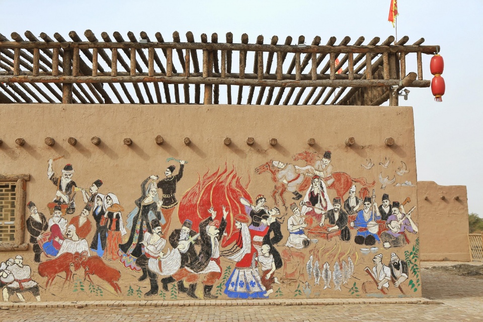 舞台墙壁上刻着少数民族欢庆的场景.