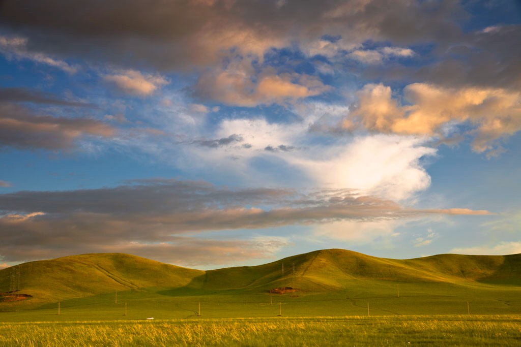 夕阳下蓝天白云草原丘陵蒙古包一幅完美和谐的自然景观
