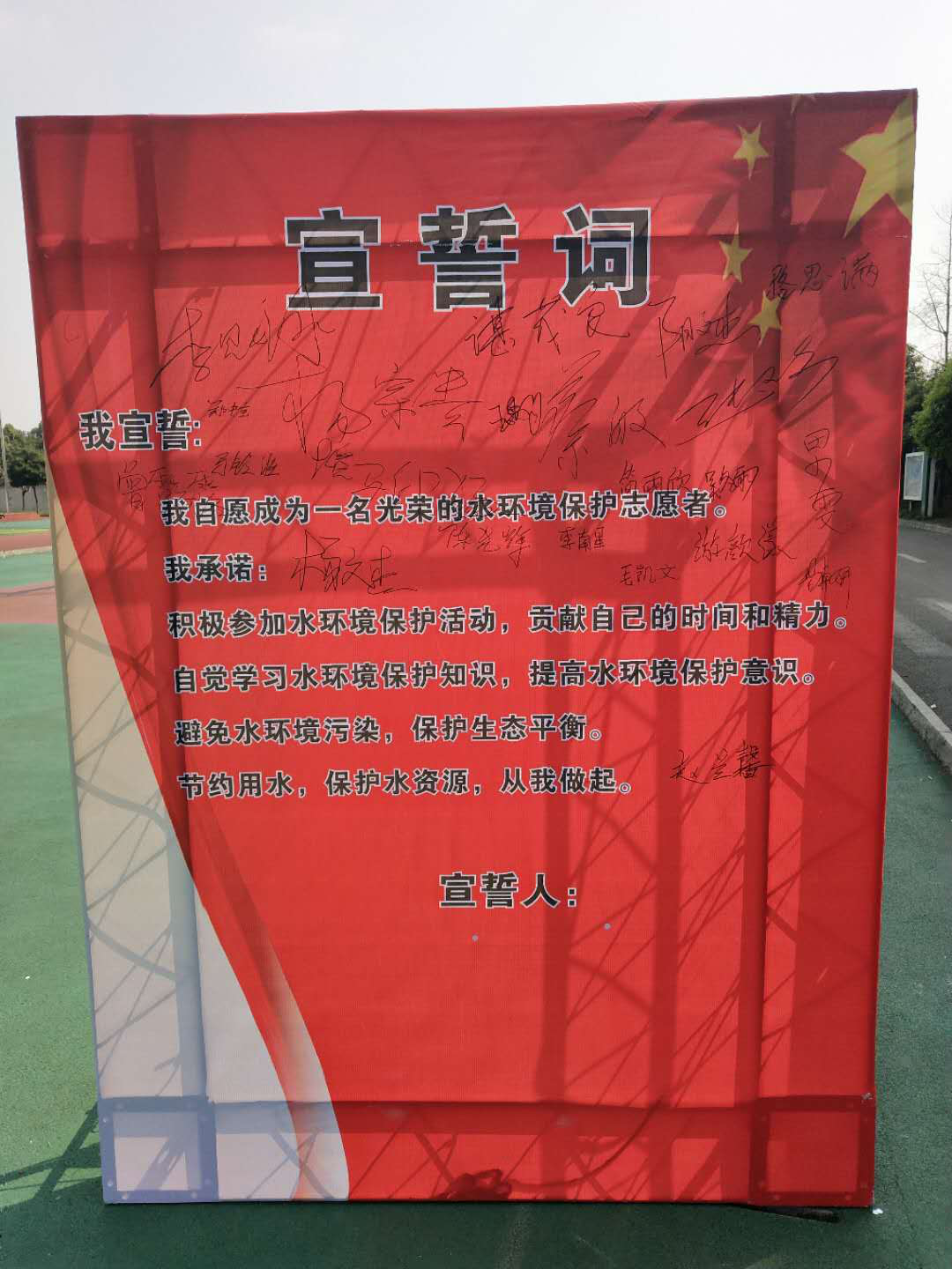 小小志愿者在宣誓词下写上自己的名字