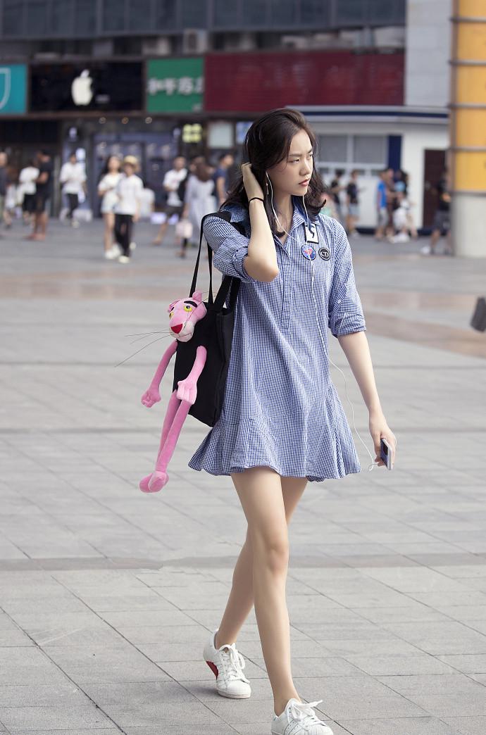 路人街拍面容精美的小姐姐过膝的黄色t恤搭配小白鞋时尚性感