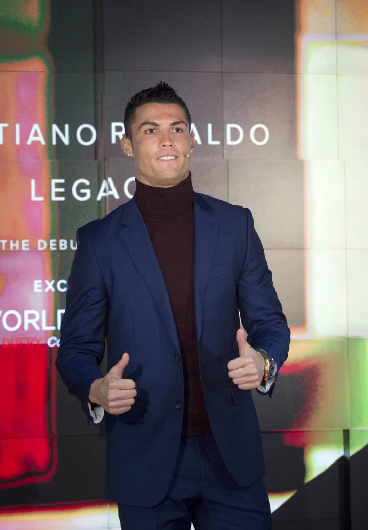 出席自己品牌下香水活动现场的c罗,身穿一套蓝色西装内搭棕褐色高领