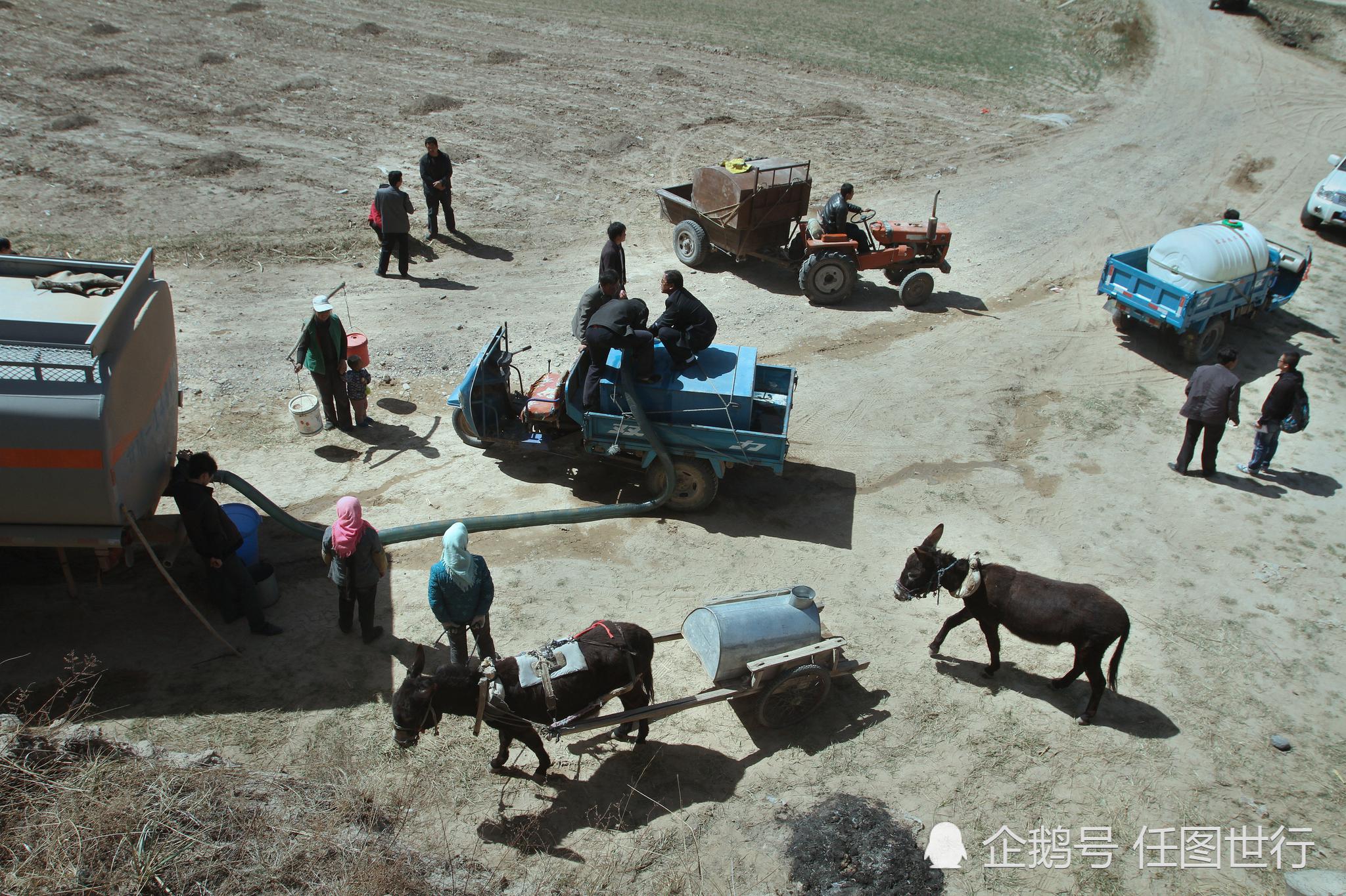 甘肃省庆阳市环县,村民在村口拉送水车送来的水.