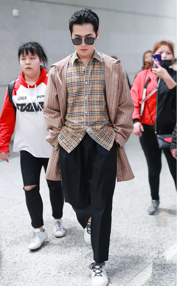 杨洋身穿驼色风衣外套内搭格纹小衬衫现身机场双手插裤袋扮帅耍酷
