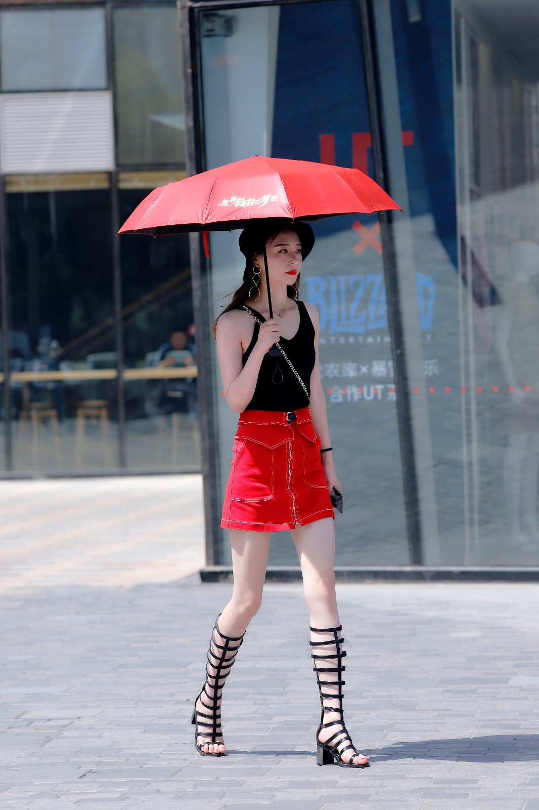 街拍:街上遇到一位小红伞女生,黑色背心红色短裙很惹眼
