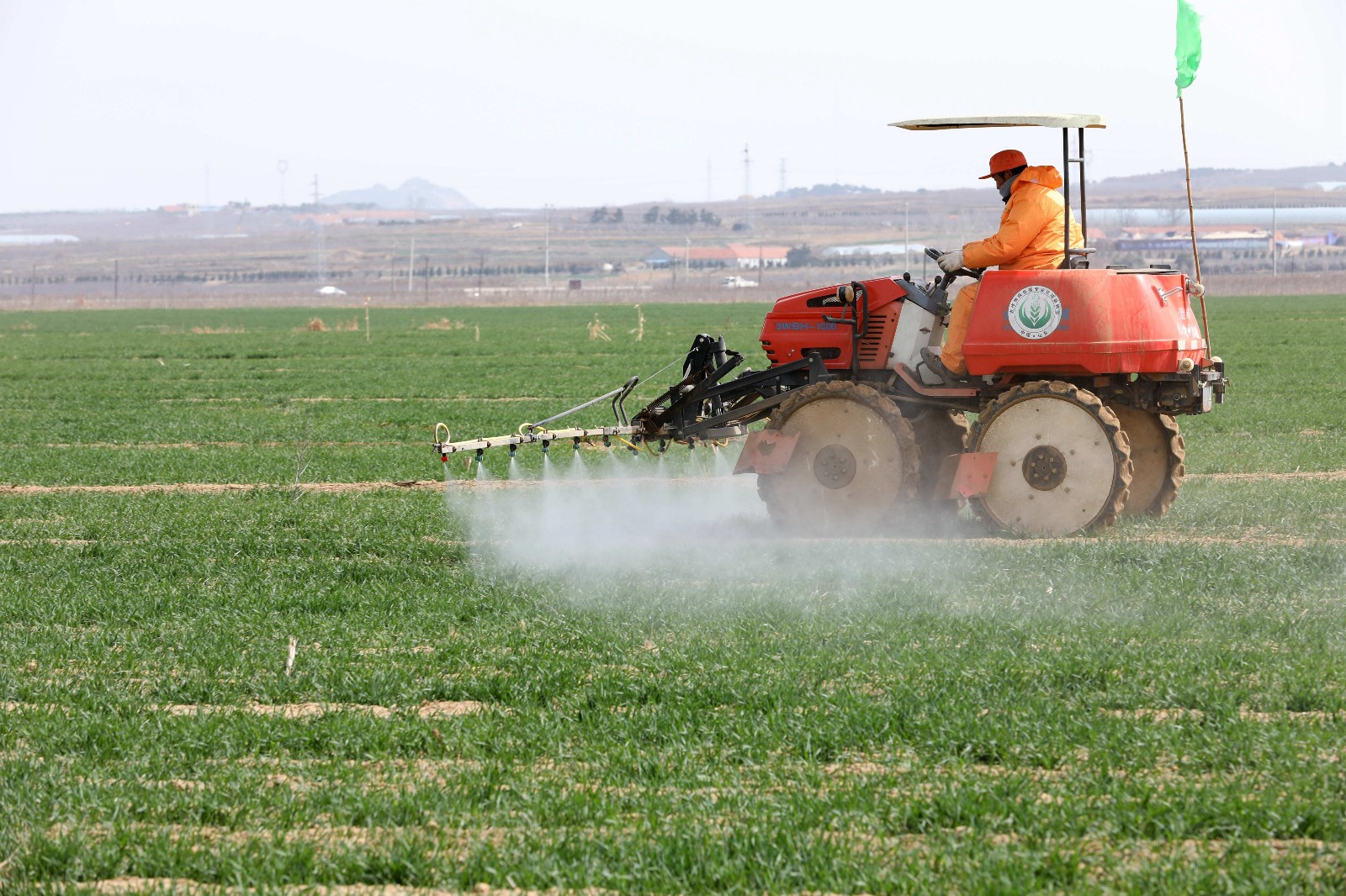 3月29日,在山东省荣成市滕家镇东滩村,农机手正在田间喷洒农药.