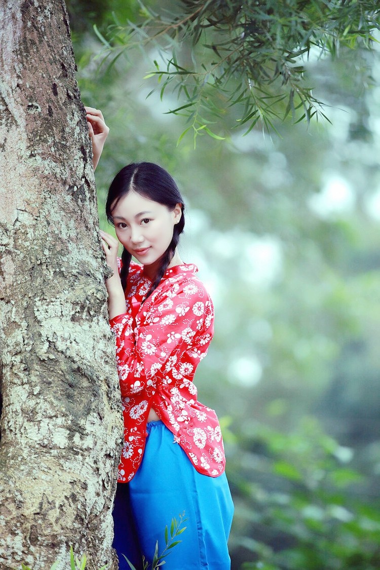 在乡村美景下的花衣小辫子姑娘