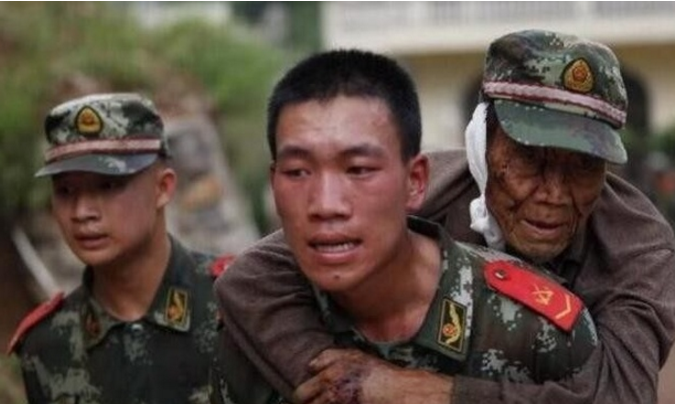 图为中国解放军战士将伤者一步步背出灾区 ,护送受伤民众到安全地带.