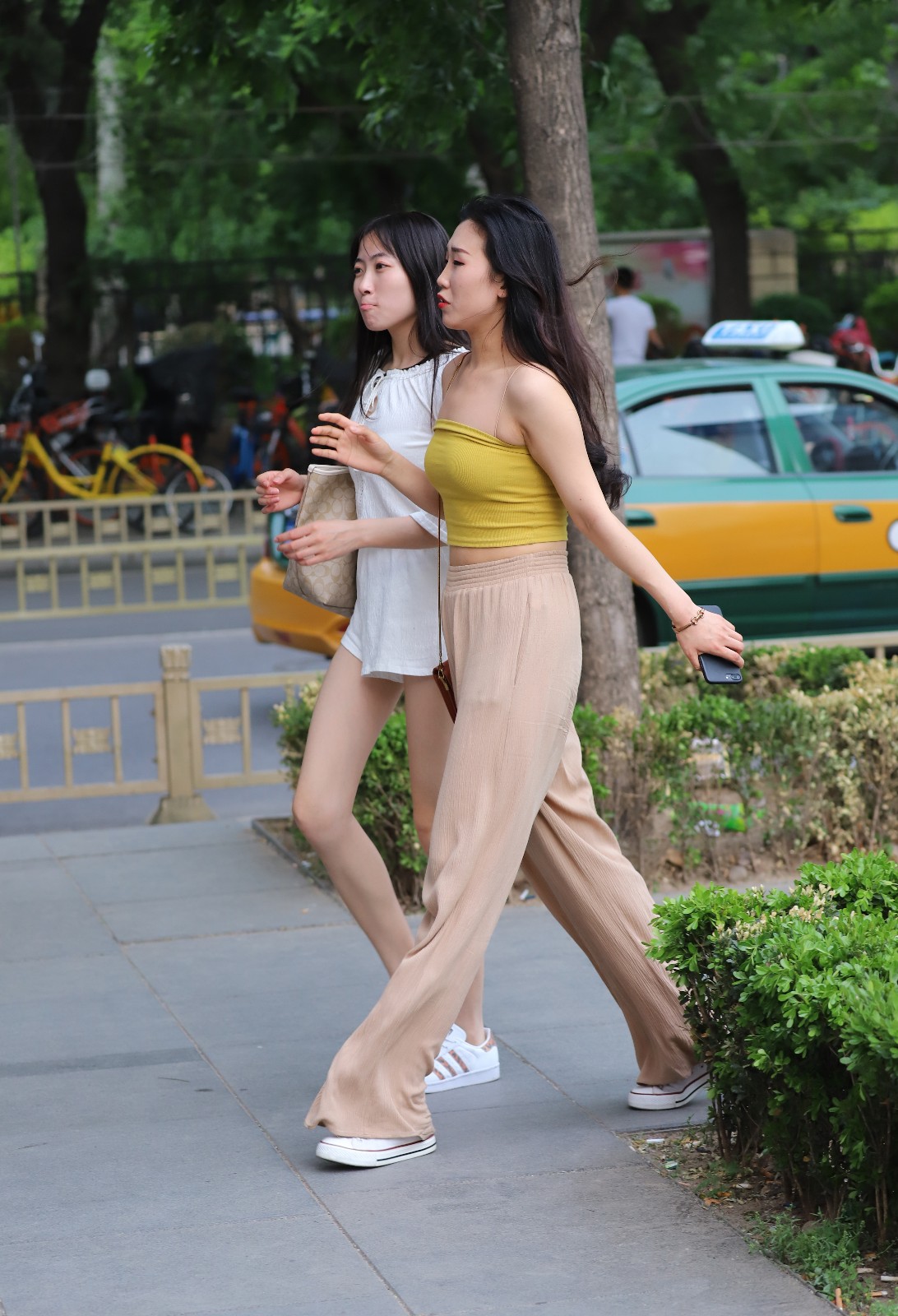 两位一起逛街的闺蜜出行穿搭各有特点,无论是露肩装或露腿装看起来都