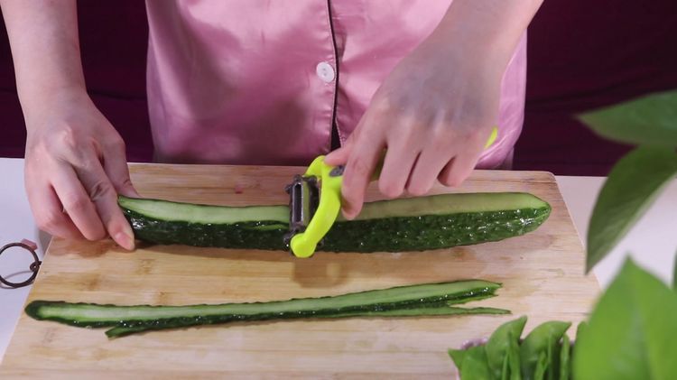 4,将黄瓜洗净后,用刮皮刀刮成长条的薄片.
