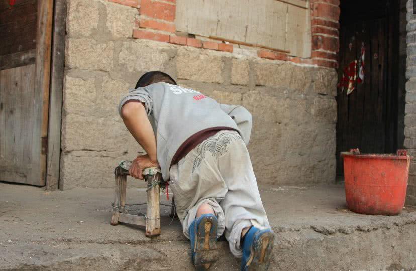 山村52岁残疾光棍汉靠凳子艰难行走如今捡废品报答母亲