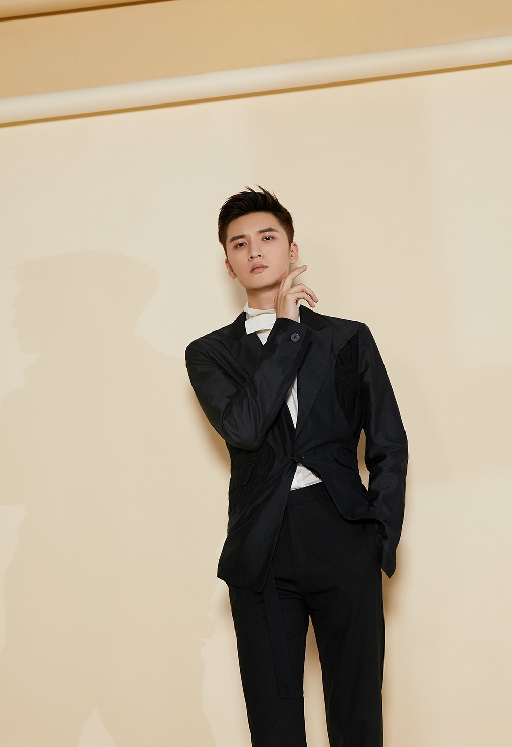 而西装的利落剪裁勾勒出他完美比例的身材,照片中刘海宽身穿纯黑西装