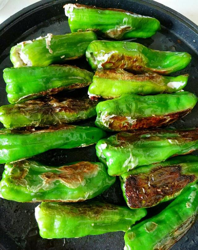 馅料炒匀,然后加入调好的调味汁煮开放入煎过的青椒开小火焖煮两分钟